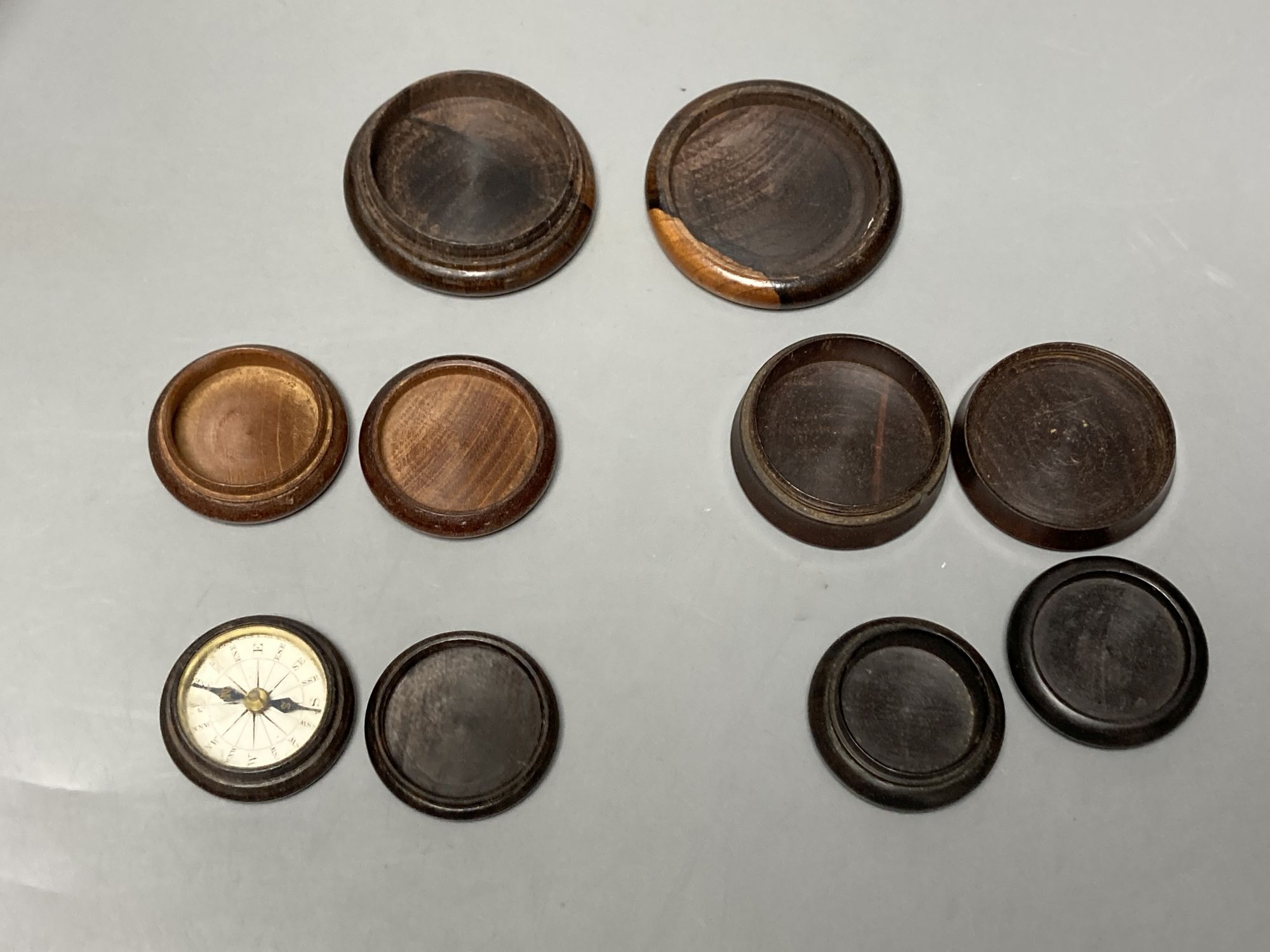 Five Tunbridge ware turned rosewood or mahogany boxes, late 19th/early 20th century, largest 5.8cm, the covers inlaid with tesserae or half square mosaic, one enclosing a compass, 3.8cm